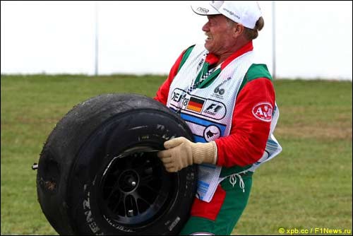 Маршал убирает колесо, оторвавшееся после аварии Лиуцци