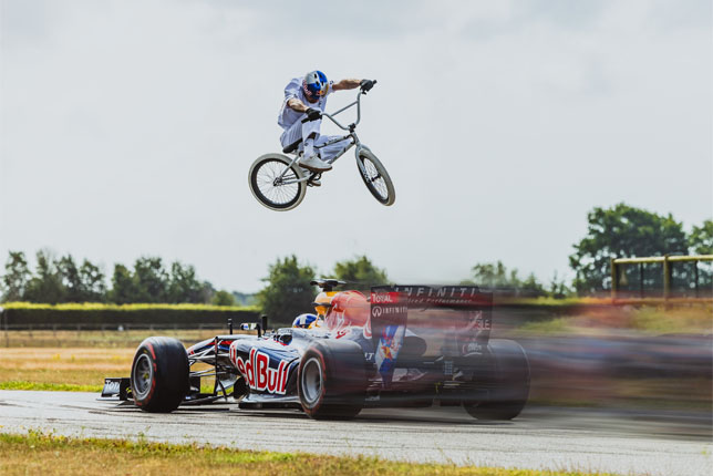 Крисс Кайл перепрыгивает движущуюся машину Формулы 1