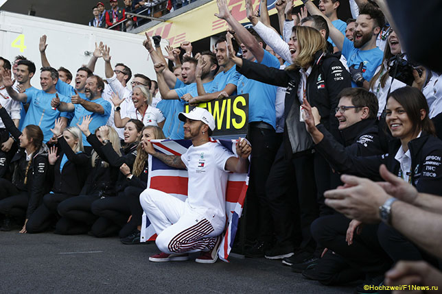 Льюис Хэмилтон празднует вместе с командой победу в чемпионате