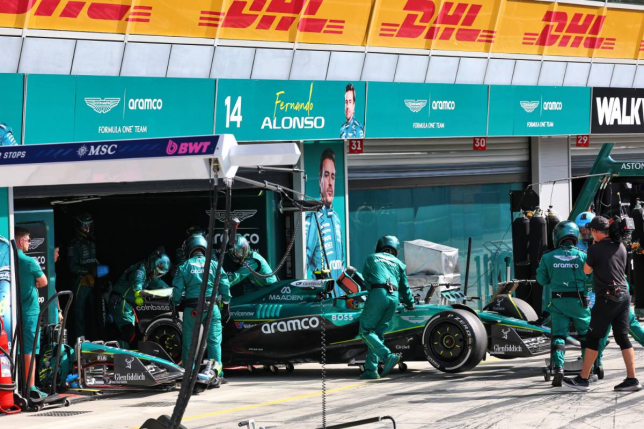 Механики Aston Martin закатывают в боксы машину Фернандо Алонсо после его схода, фото XPB