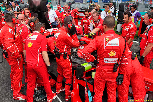 Механики Ferrari пытаются решить проблемы на машине Райкконена на стартовой решётке Гран При Малайзии