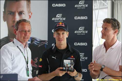 Себастьян Феттель (в центре) на пресс-конференции Casio вместе с представителем фирмы и Дэвидом Култхардом